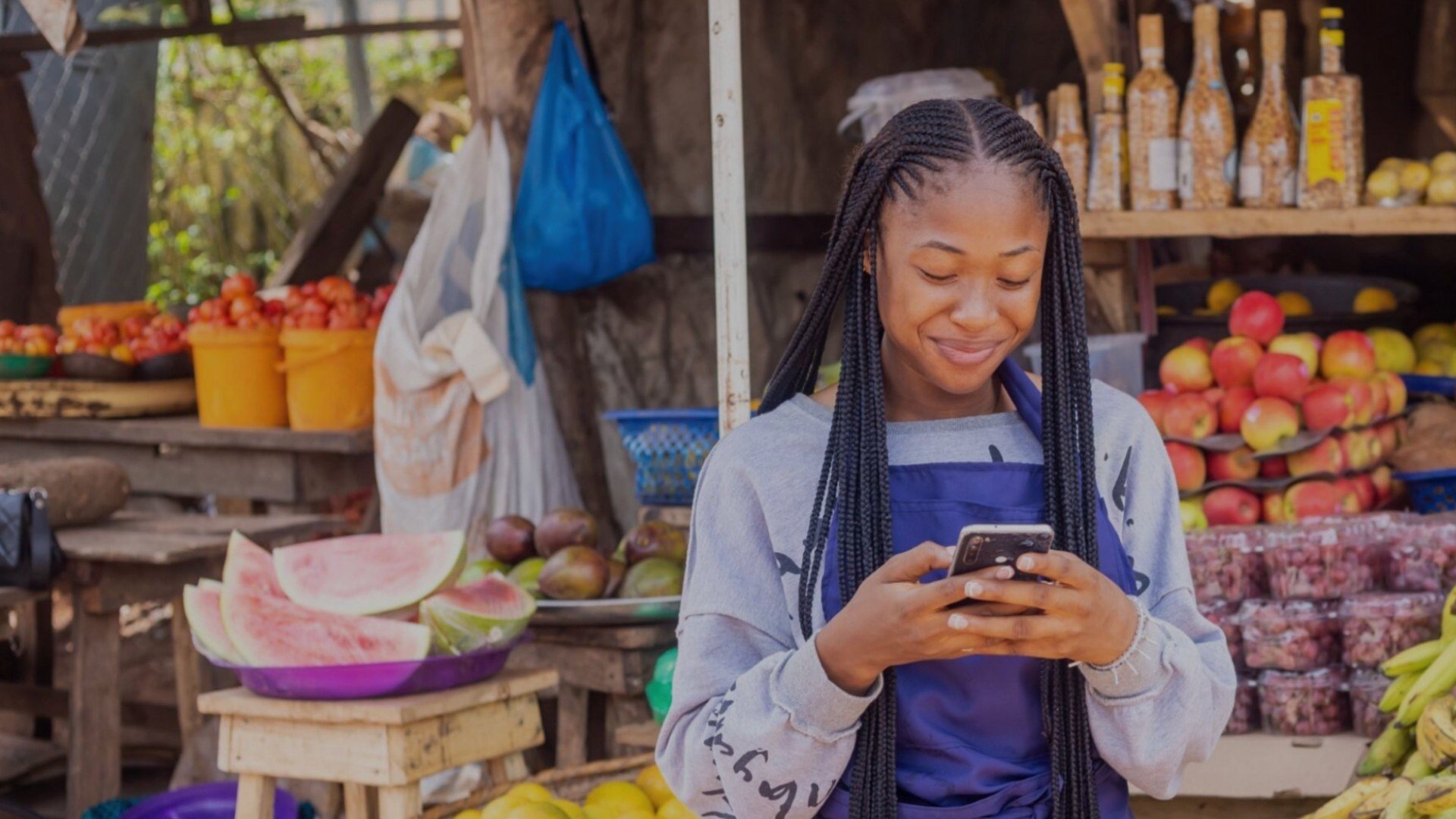 A saleswoman at the market checking her phone 