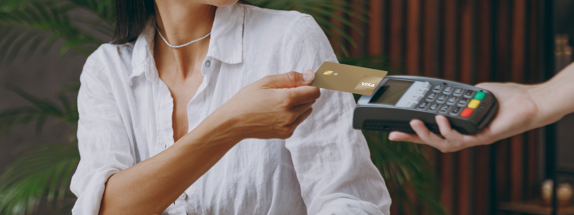 A woman paying with her Visa Gold card