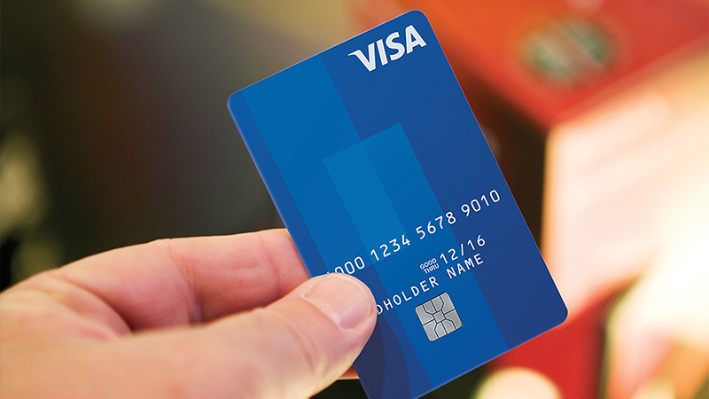 Person holding Visa chip card.