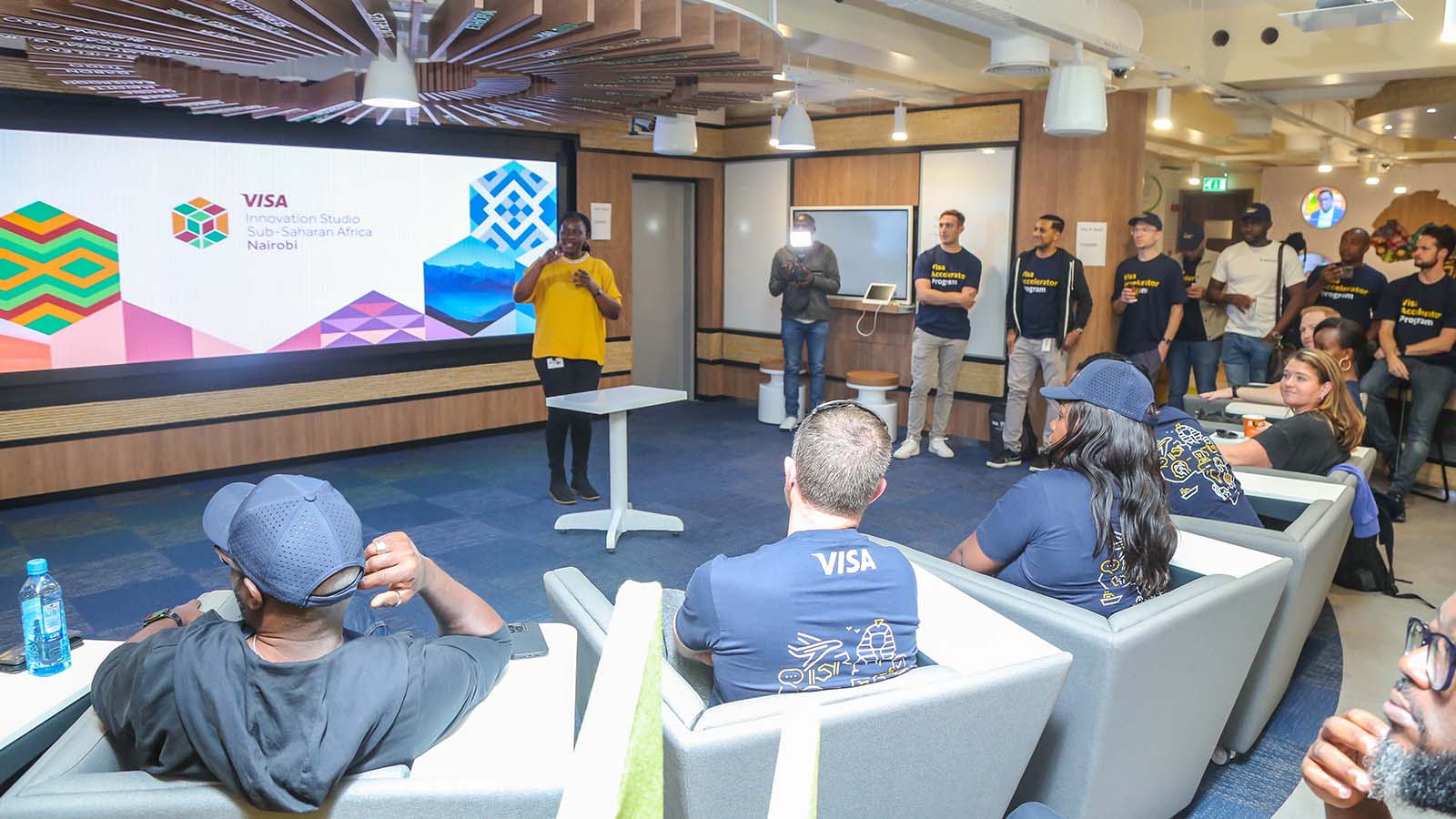 People listening and watching the presentation on a tour of Visa’s Innovation Studio in Kenya