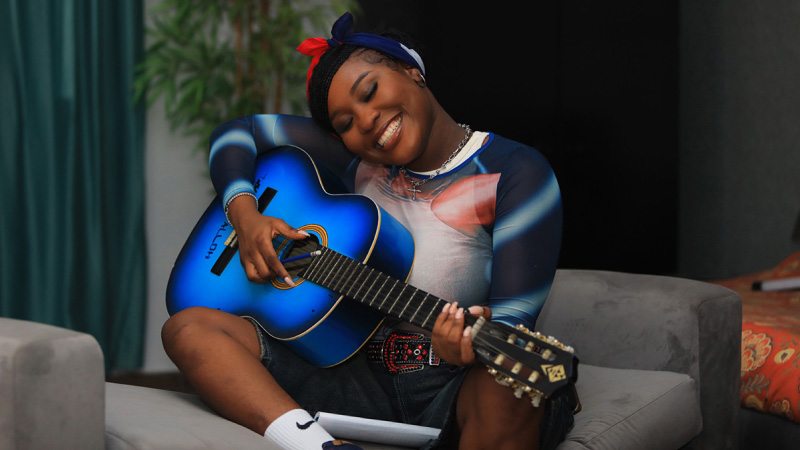 A smiling woman with a guitar